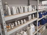 une étagère sur laquelle sont posées de nombreuses bouteilles et récipients, dans une pièce