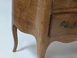 a small wooden chest of drawers on a white background