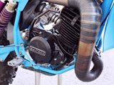 a blue dirt bike parked on a stand on the street