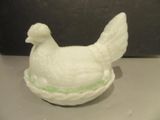 un petit poulet blanc posé sur une assiette, sur une table