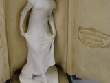 a figurine of a woman in a dress in a case