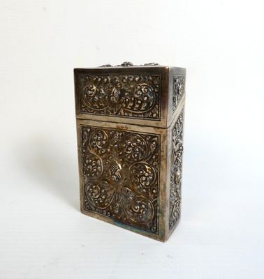 an antique brass box with a floral design on the front