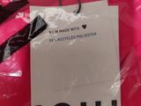 a label on a pink shirt that says i ' m made with 74 % recycled polyester