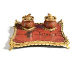 a red and gold tray with two jars on it