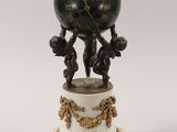 a clock that is on top of a marble pedestal
