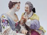 a figurine of two women sitting on a bench