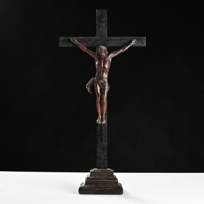 a bronze statue of jesus on the cross with a black background