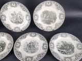 four plates with black and white designs on them sitting on a table