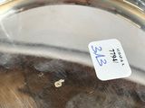 a close up of a silver plate with a tag on it