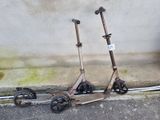 deux scooters posés par terre près d'un mur