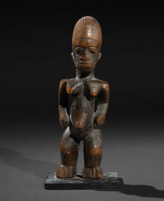 une figurine en bois représentant un homme au corps menu, posée sur une surface noire