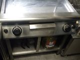 une personne se tient dans une cuisine équipée d'une cuisinière et d'un four
