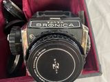 a black and silver camera in a red case
