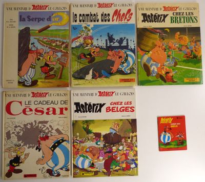 Plusieurs albums de bandes dessinées sont alignés sur une surface blanche
