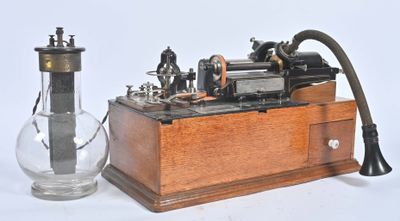 une machine à vapeur d'antan, avec un vase en verre à côté