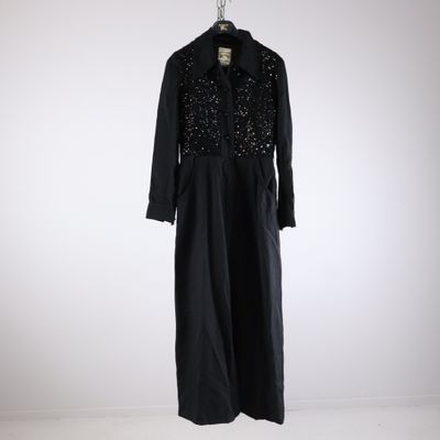 black dress with sequins on it hanging on a hanger