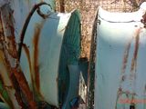 two old rusted boats sitting next to each other in the grass