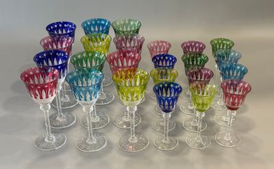 several different colored wine glasses sitting on top of a white table