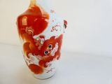 un vase rouge et blanc orné de fleurs rouges