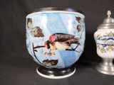 two vases with birds painted on them on a table