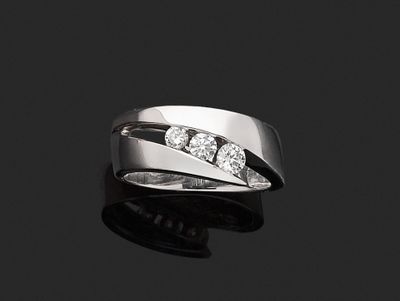 un gros plan d'une bague ornée de trois diamants sur un fond noir