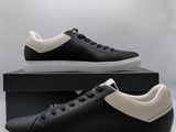 a pair of black and white sneakers sitting on top of a box