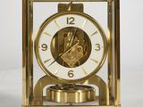 a gold clock sitting on top of a white table