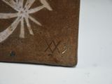 a brown tile with chinese writing on it on a table