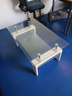 une table basse en verre posée sur un sol bleu dans une pièce