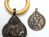 two silver and gold medals and a wooden ring on a white surface