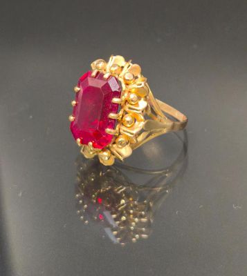 an image of a gold ring with a ruby stone in the center