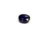 a close up of a blue sapphire stone on a white surface