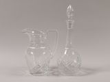 two clear glass vases and a glass bottle on a white surface