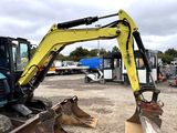 a yellow excavator that is sitting in the dirt