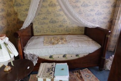 un lit surmonté d'un baldaquin, dans une chambre