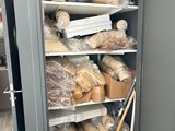 a cabinet full of bread and rolls of bread on shelves