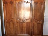 a large wooden armoire in the corner of a room
