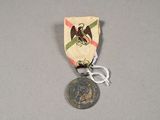 une petite médaille représentant un aigle, posée sur une table