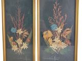 two framed floral prints of flowers and leaves on a black background