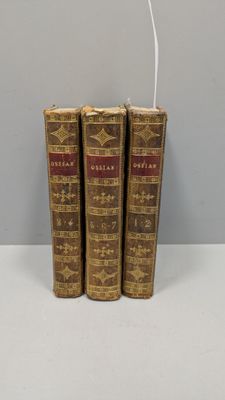 trois vieux livres posés l'un sur l'autre sur une table