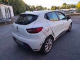 the rear end of a white car that has been badly damaged