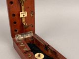 a small wooden box with a key in it on a white surface