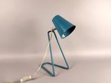 the blue lamp is on a metal stand with a white cord