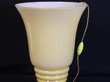 a yellow vase with a chain around it on a black background
