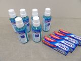 quatre tubes de dentifrice et quatre tubes de dentifrice posés les uns à côté des autres