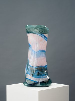 un vase en verre posé sur un socle blanc