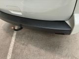 the rear end of a white car parked in a parking lot