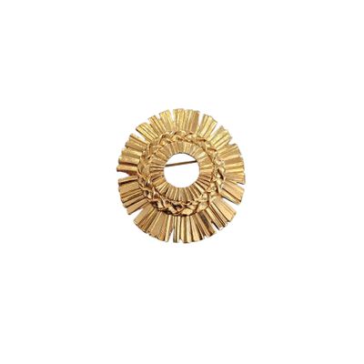 a close up of a gold brooch on a white background