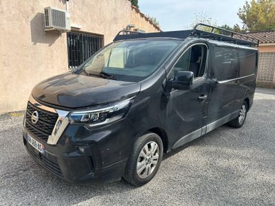une camionnette noire garée devant un immeuble, sur un parking