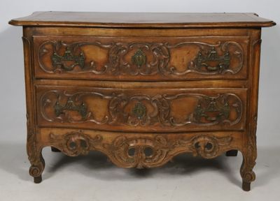 COMMODE à façade galbée en noyer mouluré et sculpté d'acanth…